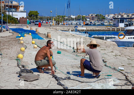 Die Fischer ihre Netze reparieren am Hafen von Porto Colom, Mallorca, Balearen, Spanien Stockfoto