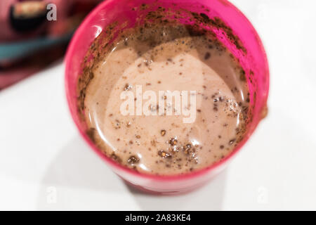 Schokolade mit Milch auf einem rosafarbenen Glas Stockfoto