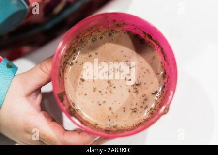 Schokolade mit Milch auf einem rosafarbenen Glas Stockfoto