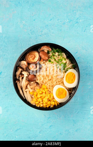 Ramen. Soba Nudeln mit gekochten Eiern, Shiitake-pilze, und Gemüse, Schuß von der Oberseite auf blauem Hintergrund mit einem Platz für Text Stockfoto