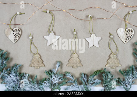 Flatlay Zusammensetzung von Holz- Weihnachtsschmuck auf dem Papier Hintergrund. Platz kopieren, Ansicht von oben. Weihnachten, Winter, neues Jahr. Stockfoto