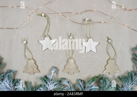 Flatlay Zusammensetzung von Holz- Weihnachtsschmuck auf dem Papier Hintergrund. Platz kopieren, Ansicht von oben. Weihnachten, Winter, neues Jahr. Stockfoto