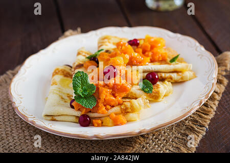 Pfannkuchen. Französische Crepes mit karamellisierten Scheiben von Kürbis und Apfel mit Honig. Stockfoto