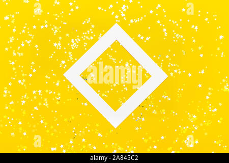 Kreative Gestaltung mit weißen Raute Rahmen und kleine goldene Sterne auf gelben Hintergrund. Stockfoto