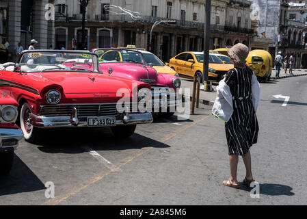 Ein Tourist, der eine Reihe amerikanischer Oldtimer im Parque Central in Havanna, Kuba, Bewundert, Viele der aufsehenerregenden Cabrio-Klassiker American Ca Stockfoto