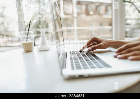 Kaukasische Finger tippen auf Laptop keyabord auf weißer Tisch. Stockfoto