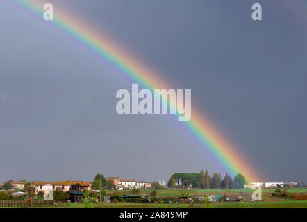 Einen schönen Regenbogen gegen einen dunklen Himmel mit Blick auf die toskanische Landschaft Stockfoto