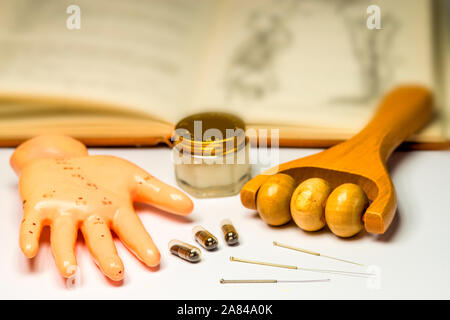 Akupunktur Nadeln mit Hand Modell, Massageroller, Pillen, Salbe und Lehrbuch Stockfoto