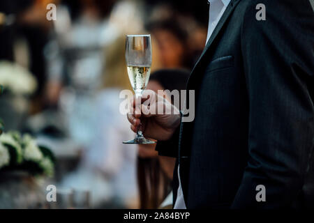 Mann und Frau sind Holding und gießen Wein bei gesellschaftlichen Veranstaltungen und Hochzeiten. Stockfoto