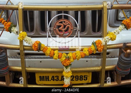 Ein Lkw in Indien mit einer Heiligen ॐ (Aum, OM) Symbol und eine Girlande aus Ringelblume Blumen, für gute und Unfallfreie Fahrten eingerichtet Stockfoto