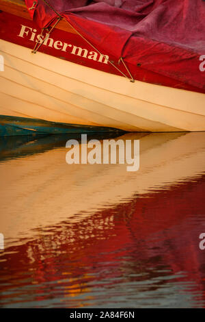 Reflektion von einem kleinen Boot im Hafen bei Ebbe. Stockfoto