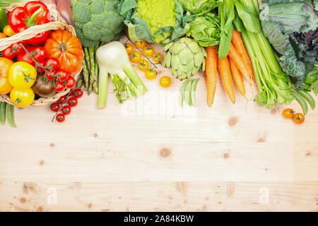 Blick von oben auf die Gemüse auf Holztisch und Weidenkorb, Karotten velery Tomaten weißkohl Brokkoli, Kopie, selektiven Fokus Stockfoto