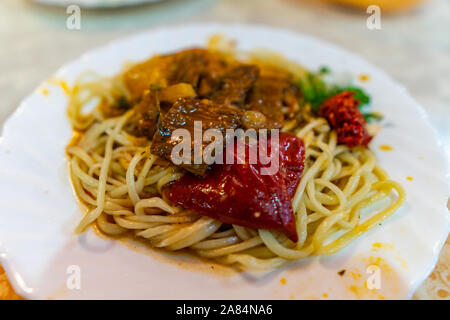 Traditionelle Mouthwatering Zentralasiatischen Uigurischen gebratene Nudeln Lagman Hauptgericht mit Gemüse auf einem weißen Teller Stockfoto