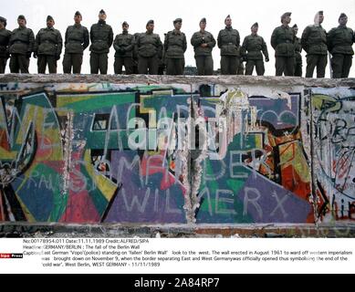 Ostdeutsche "Vopo" (Polizei) steht auf "gesunken" Berliner Mauer' Blick in den Westen. Die Mauer errichtet, im August 1961, als die Grenze zwischen Ost und West war damit offiziell eröffnet als Symbol für das Ende des Kalten Krieges. West Berlin, West Germany - 11/11/1989 (ALFRED/SIPA/IPA/Fotogramma, WEST BERLIN - 2014-10-17) ps das Foto kann in Bezug auf den Kontext, in dem es aufgenommen wurde verwendet werden, und ohne beleidigende Absicht der Anstand der Personen vertreten die redaktionelle Nutzung Stockfoto