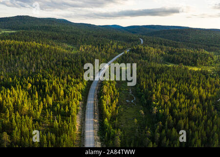 Eine Straße führt durch die finnische Landschaft Stockfoto