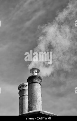 Dampf/Rauch, der von den inländischen Schornstein Stockfoto
