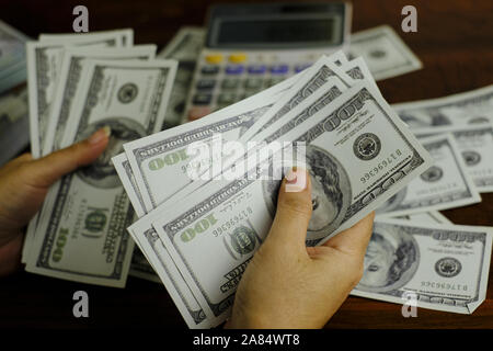 Unternehmer Frauen zählen Geld auf einem Stapel von 100 US-Dollar Banknoten Stockfoto