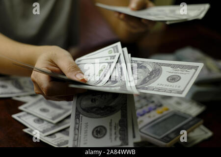 Unternehmer Frauen zählen Geld auf einem Stapel von 100 US-Dollar Banknoten Stockfoto