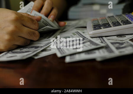 Unternehmer Frauen zählen Geld auf einem Stapel von 100 US-Dollar Banknoten Stockfoto