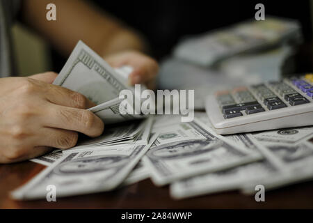 Unternehmer Frauen zählen Geld auf einem Stapel von 100 US-Dollar Banknoten Stockfoto