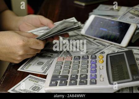 Unternehmer Frauen zählen Geld auf einem Stapel von 100 US-Dollar Banknoten Stockfoto