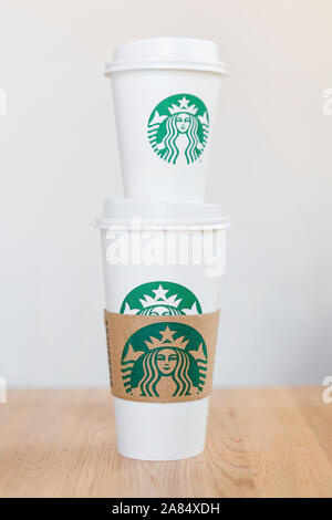 Kiew, Ukraine/November 06, 2019: Starbucks Kaffee nehmen Pappbecher mit Logo auf Holz- zähler Tabelle. American global Kaffee und Kaffeehaus Stockfoto