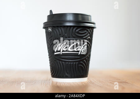 Kiew, Ukraine/November 06, 2019: McDonald's Kaffee in schwarzer Schale McCafe auf Holztisch auf hellen Hintergrund. Stockfoto