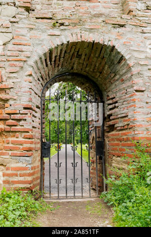 Geschlossen und Verriegelt metal Iron Gate in alten Mauer Stockfoto