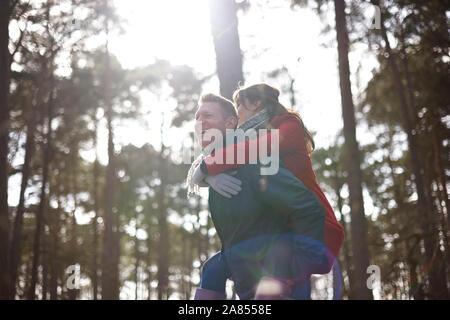 Fröhlicher, verspielter Paar in Sunny woods Netzwerk zugreift. Stockfoto