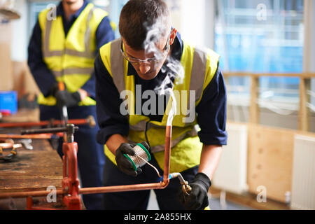 Männliche Kursteilnehmer arbeiten mit Kupfer im Shop klasse Workshop Stockfoto