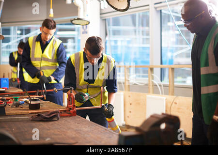Männliche Kursleiter beobachten student Schweißen in Werkstatt Stockfoto