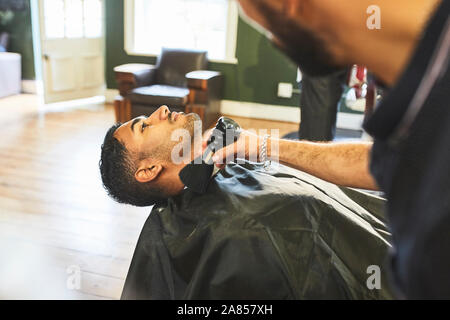 Männliche Friseur bürsten Gesicht der Kunden in der Barbershop Stockfoto