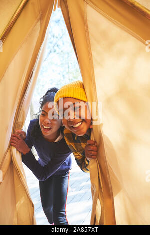 Verspielte Bruder und Schwester Spähen in camping Tipi Stockfoto