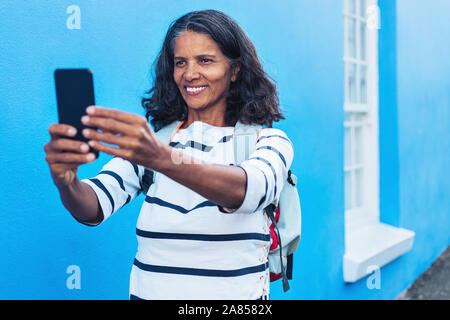 Gerne weibliche Tourist, selfie mit smart phone Stockfoto