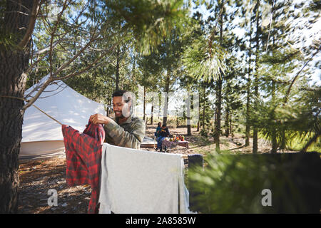 Mann hängende Wäsche auf der Wäscheleine auf einem Campingplatz im Wald Stockfoto
