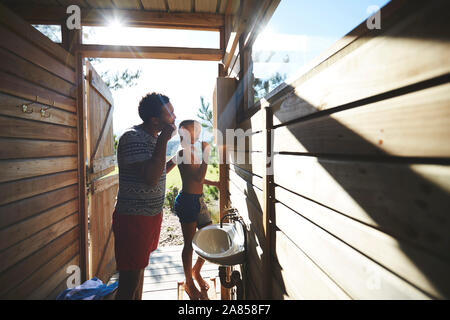 Vater und Sohn Zähneputzen bei Sunny Campingplatz bad Spiegel Stockfoto