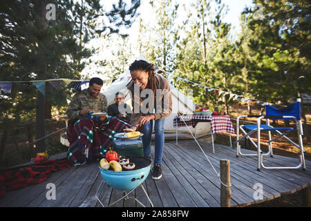 Familie kochen Gemüse camping Grill in Holz Stockfoto
