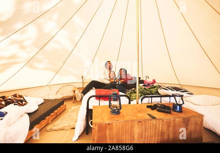 Glückliche, unbeschwerte Familie entspannen auf Bett im Camping Jurte