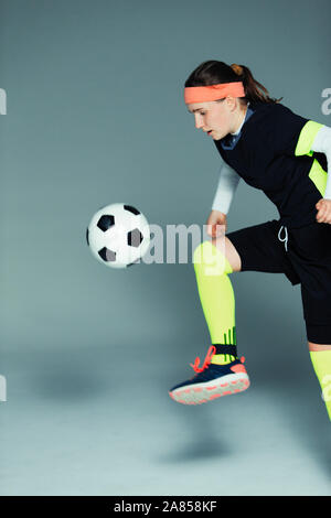 Junges Mädchen Fußball-Spieler kicken den Ball Stockfoto