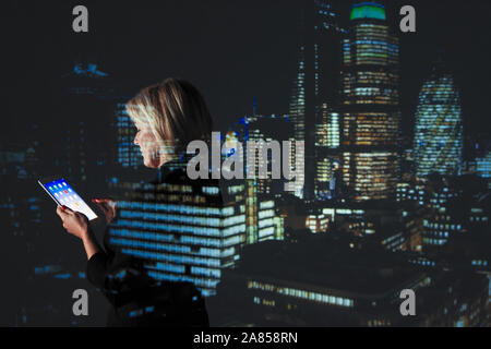 Double Exposure Geschäftsfrau mit digitalen Tablette gegen Hochhaus Lichter in der Nacht Stockfoto