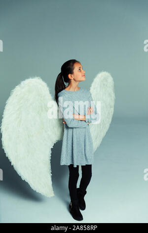 Portrait zuversichtlich, neugierig Mädchen mit Angel Wings, Suchen nach Stockfoto