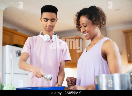 Mutter und Sohn im Teenageralter Kochen in der Küche Stockfoto