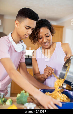 Mutter und Sohn im Teenageralter Kochen in der Küche Stockfoto