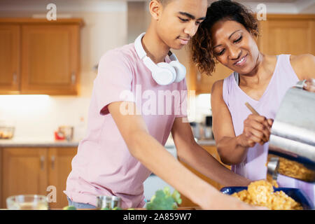 Mutter und Sohn im Teenageralter Kochen in der Küche Stockfoto