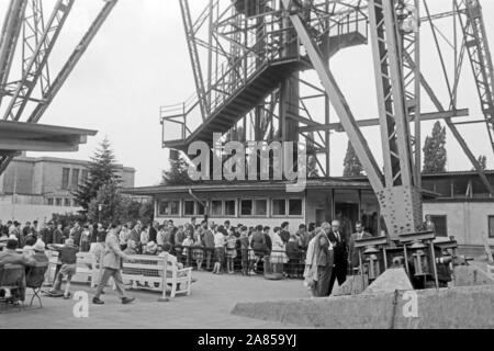 Besucherschlange vor der Kasse am Fuße vom Funkturm in Berlin, Deutschland 1961. Die Leute in der Warteschlange an der Kasse im Erdgeschoss der Berliner Funkturm, Deutschland 1961. Stockfoto