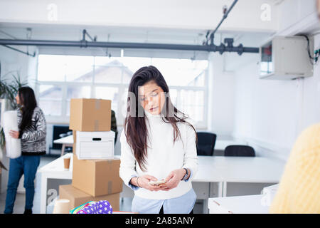 Geschäftsfrau mit Smart Phone im neuen Büro Stockfoto