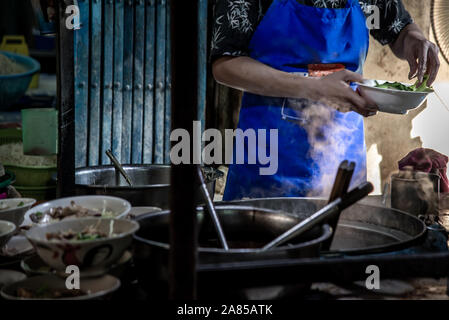 Bangkok, Thailand - 27 Okt 2019: Küchenchef ei Nudeln mit gebratenem Schweinefleisch in einem lokalen Restaurant, Thailand Street Food. Die Nudel in den traditionellen EIN Stockfoto