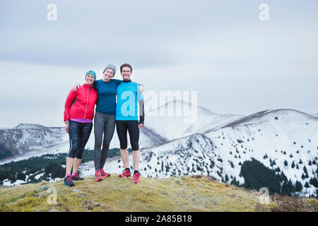 Portrait happy family Wandern auf verschneite Berggipfel, Lake District, Großbritannien Stockfoto