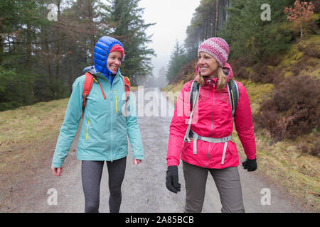 Frauen wandern auf Trail in feuchten Wäldern Stockfoto