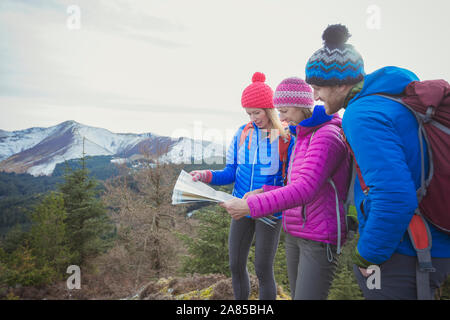 Freunde mit Karte wandern mit Bergen im Hintergrund Stockfoto